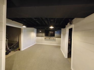 Newly remodeled basement in Lancaster NY with the ceiling professionally painted black by Carrigan Painting